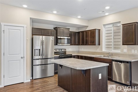 A modern kitchen with stainless steel appliances and wooden cabinets.