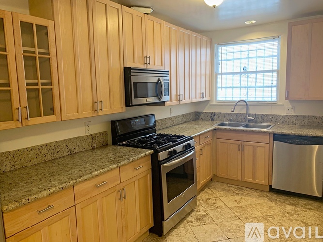 A kitchen with wooden cabinets and granite countertops.