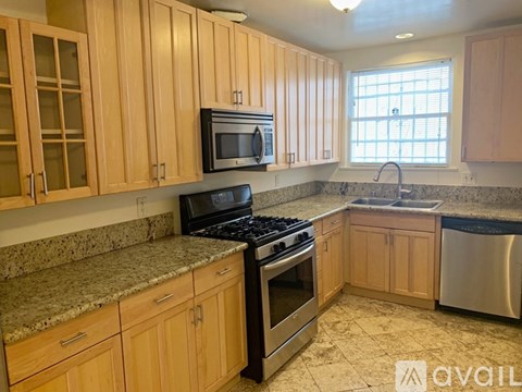 A kitchen with wooden cabinets and granite countertops.