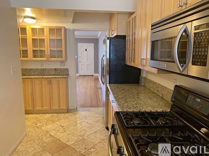 A kitchen with a black refrigerator and a stove top oven.