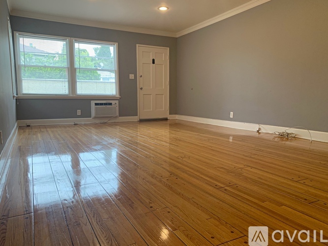 A room with wooden flooring and a white door.