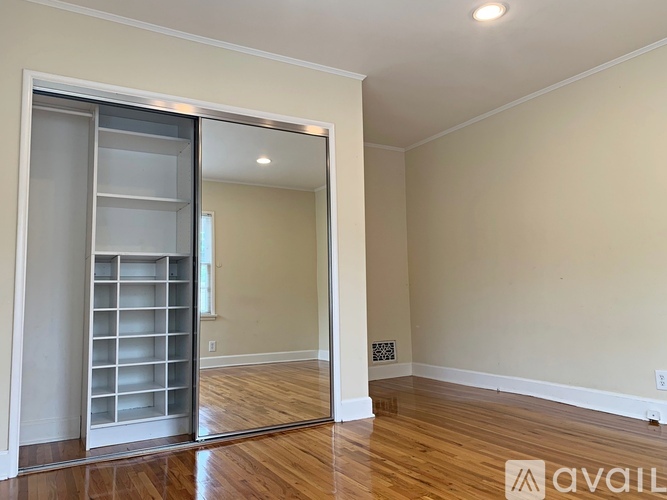 A room with a sliding door and wooden flooring.