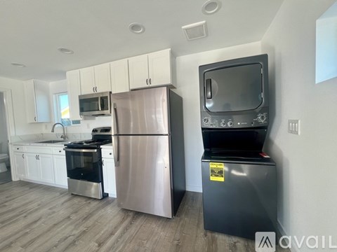A kitchen with a refrigerator and a microwave.