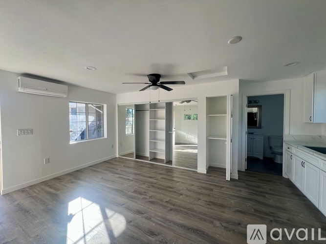 A spacious room with a ceiling fan and a large window.
