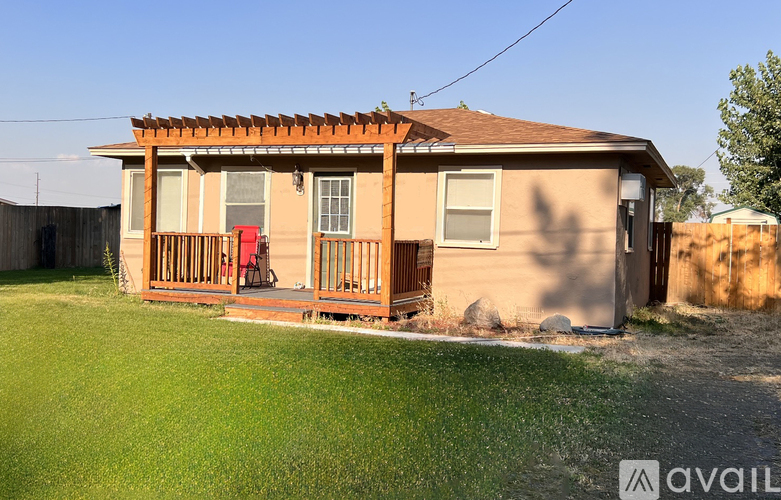 A house with a red chair on the porch is for sale.