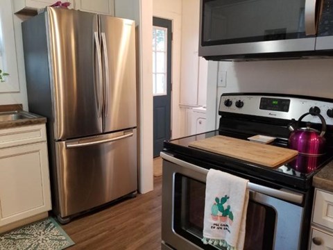 A kitchen with a stainless steel refrigerator and oven.