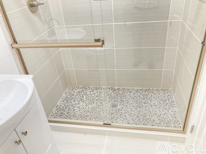 A white bathroom with a shower and a white sink.
