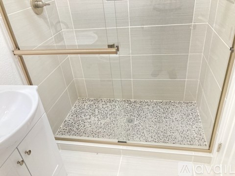 A white bathroom with a shower and a white sink.
