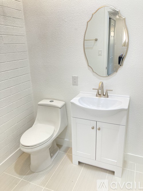 A white toilet and sink in a bathroom.