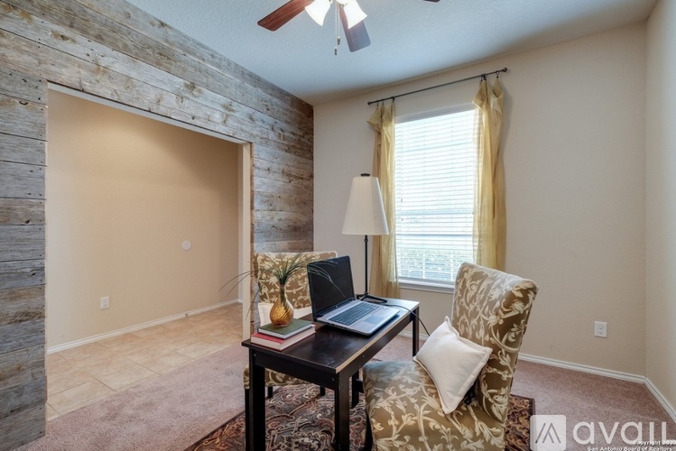 A room with a stone wall and a table with a laptop on it.