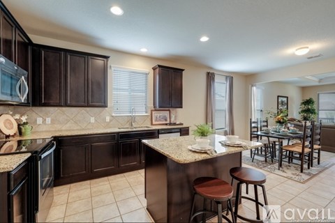 A kitchen with brown cabinets and a granite countertop.