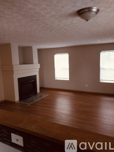 A living room with a fireplace and wood flooring.