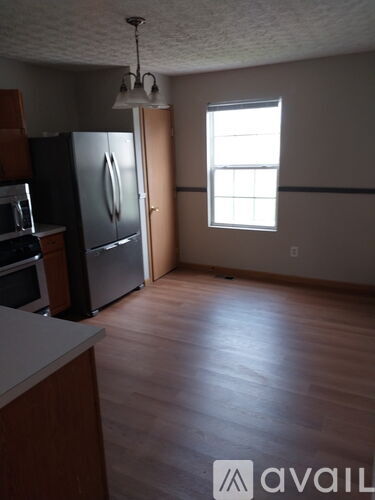 A kitchen with a refrigerator, oven, and microwave.