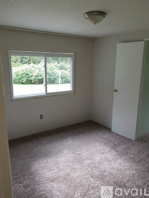 A room with a window and a door is available for rent.