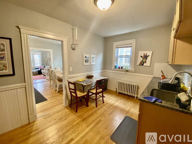 A kitchen with a dining table and chairs.