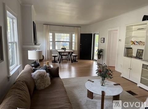 A living room with a brown couch and a white coffee table.