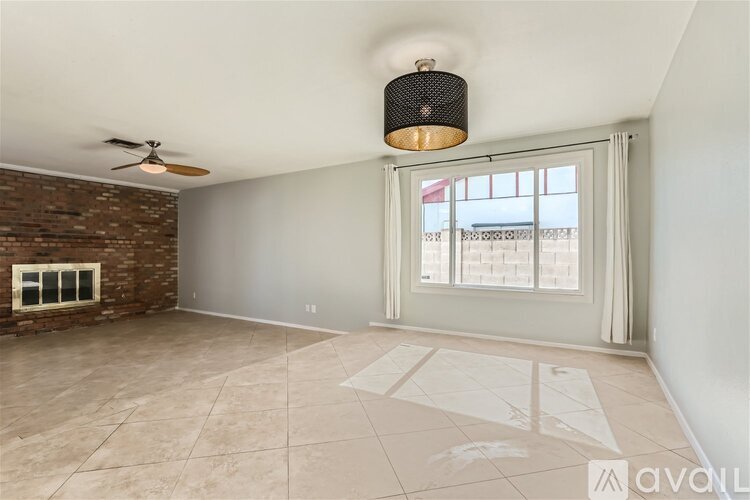 A room with a ceiling fan and a window with a view of a cityscape.