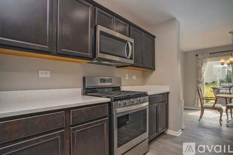 A kitchen with dark brown cabinets and a stainless steel oven.