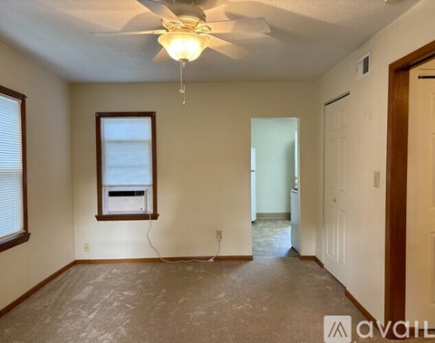 A room with a ceiling fan and a window.