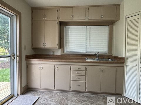 A kitchen with beige cabinets and a sink.