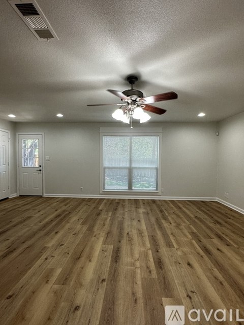 A room with wooden flooring and a ceiling fan.