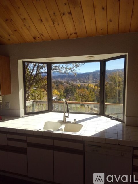 A bathroom with a large window overlooking a mountainous landscape.