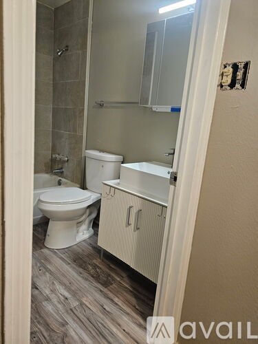 A bathroom with a toilet, sink, and shower.