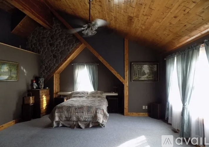 A bedroom with a large bed and a ceiling fan.