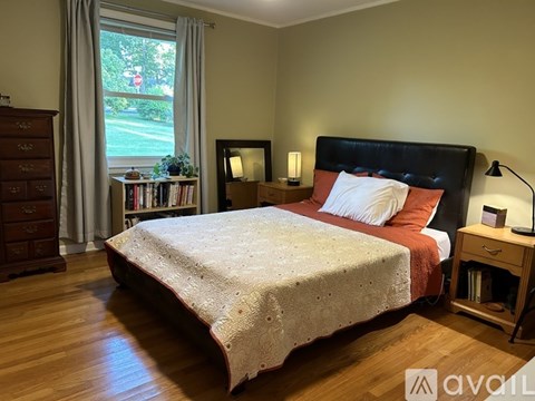 A bedroom with a large bed and a window overlooking a street.