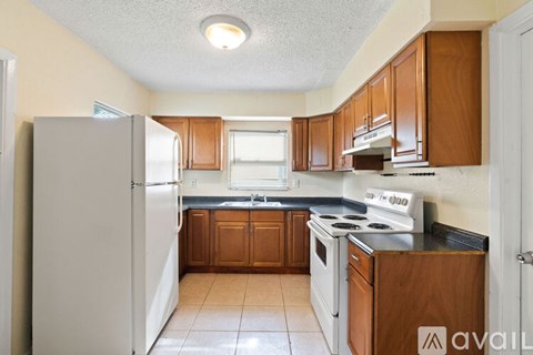 A kitchen with wooden cabinets and a white refrigerator.