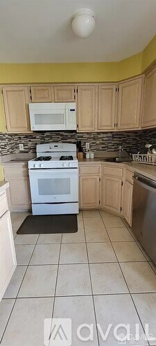 A kitchen with a white stove top oven and a white microwave above it.