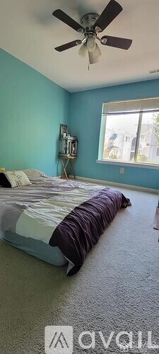 A bedroom with a bed and a ceiling fan.