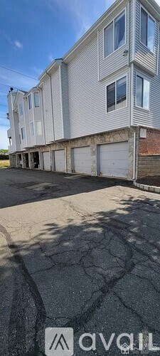 A large, multi-story building with a flat roof and a garage door.