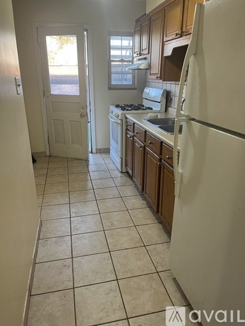 A kitchen with a white fridge and a white door.
