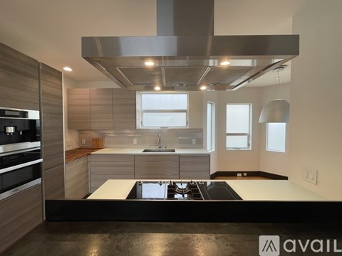 A modern kitchen with a stove top oven and a sink.