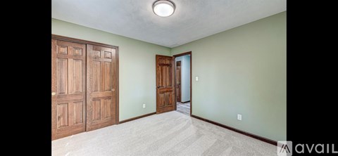 A room with a green wall and a wooden door.