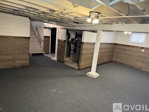 A spacious room with wooden walls and a carpeted floor.