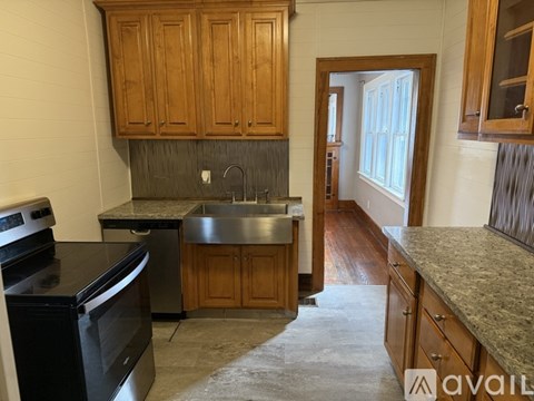 A kitchen with wooden cabinets and a black stove top oven.