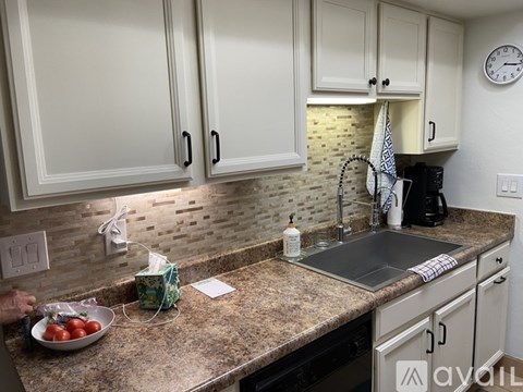A kitchen with granite countertops and white cabinets.