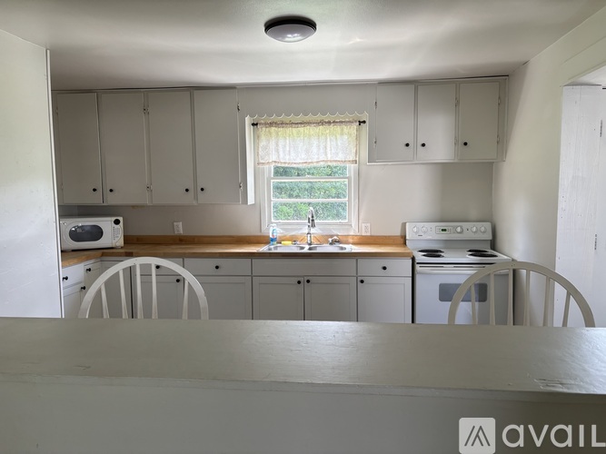 A kitchen with white cabinets and appliances.