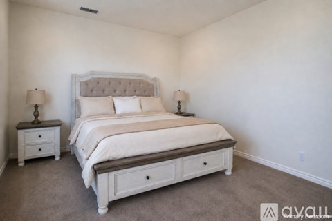 A bedroom with a large bed and two nightstands.