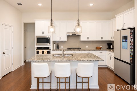 A kitchen with white cabinets and a granite countertop.