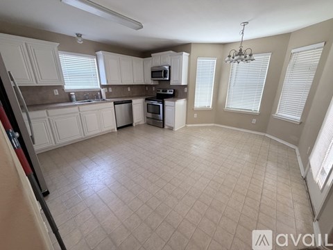 A kitchen with white cabinets and a tile floor.