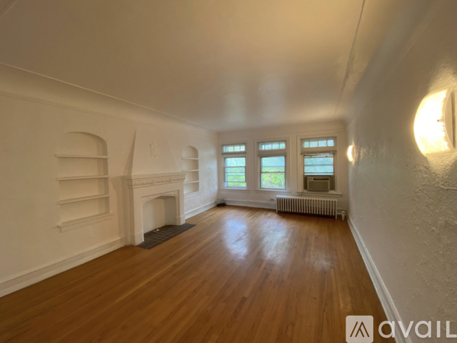 A spacious room with wooden floors and white walls.