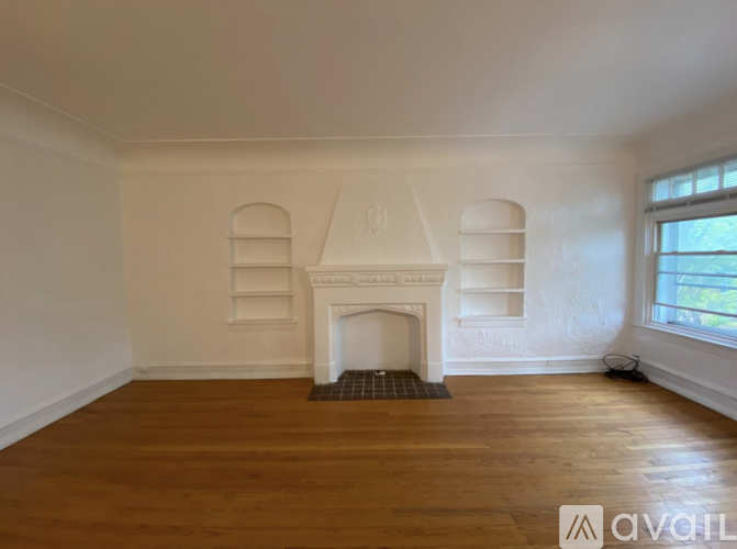 A room with a fireplace and wooden floors.