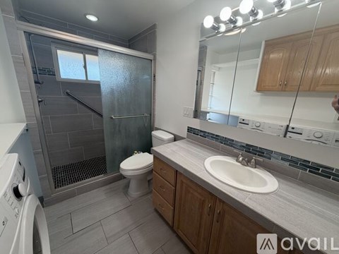 A bathroom with a toilet, sink, and shower.