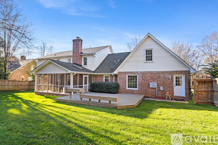 A house with a white roof and a brick chimney is for sale.