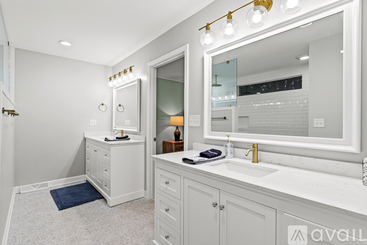 A bathroom with a white vanity and a mirror above it.