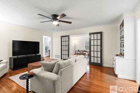 A living room with a grey couch and a black television.