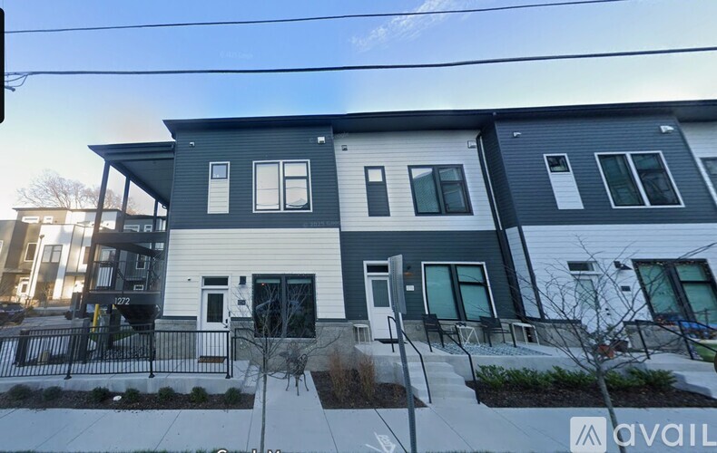 A modern two-story house with a front yard and a driveway.